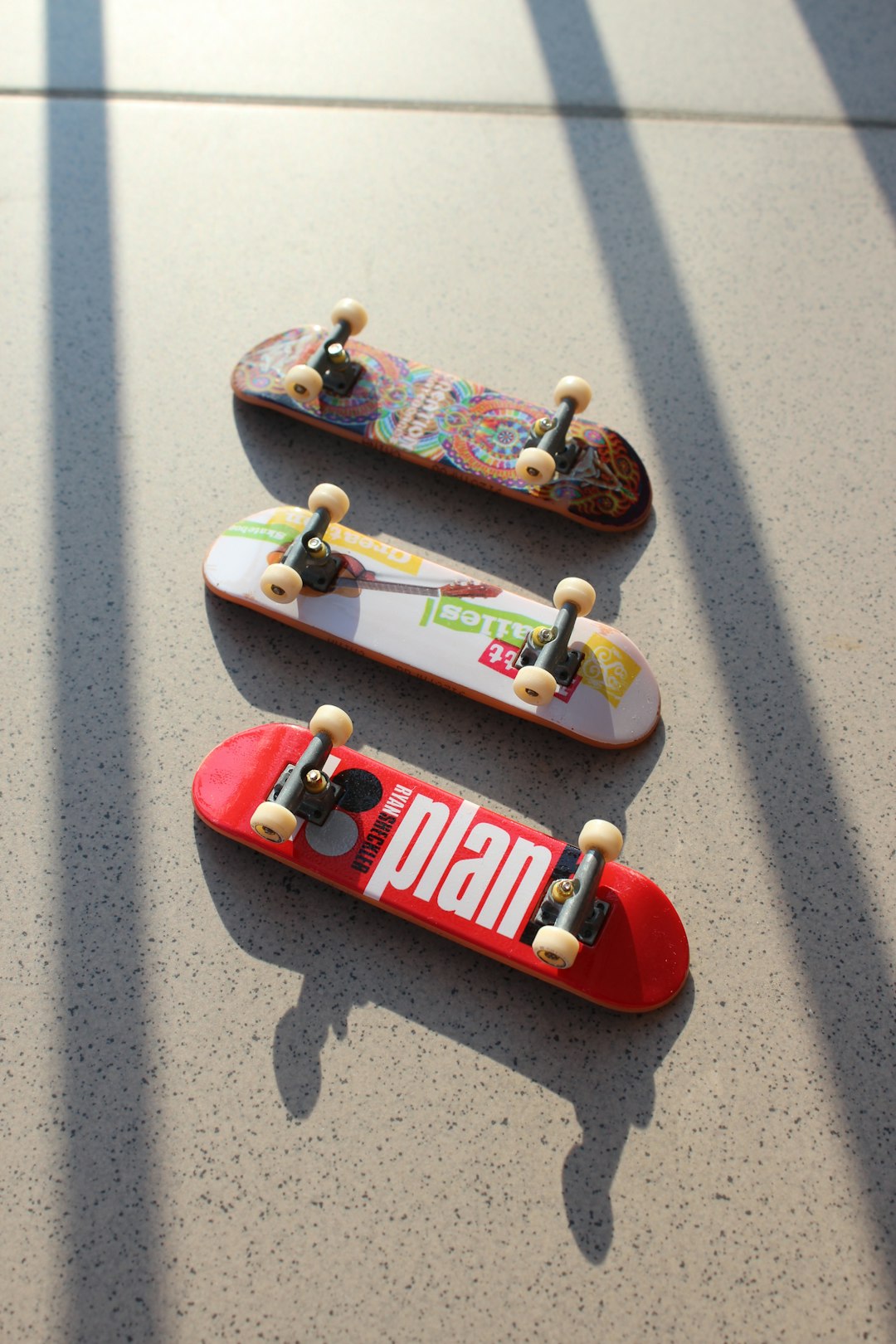 Tech Deck skateboards chilling in the sun in a cool position, creating very poetic shadows. by Skateboard Brands three assorted-color fingerboards