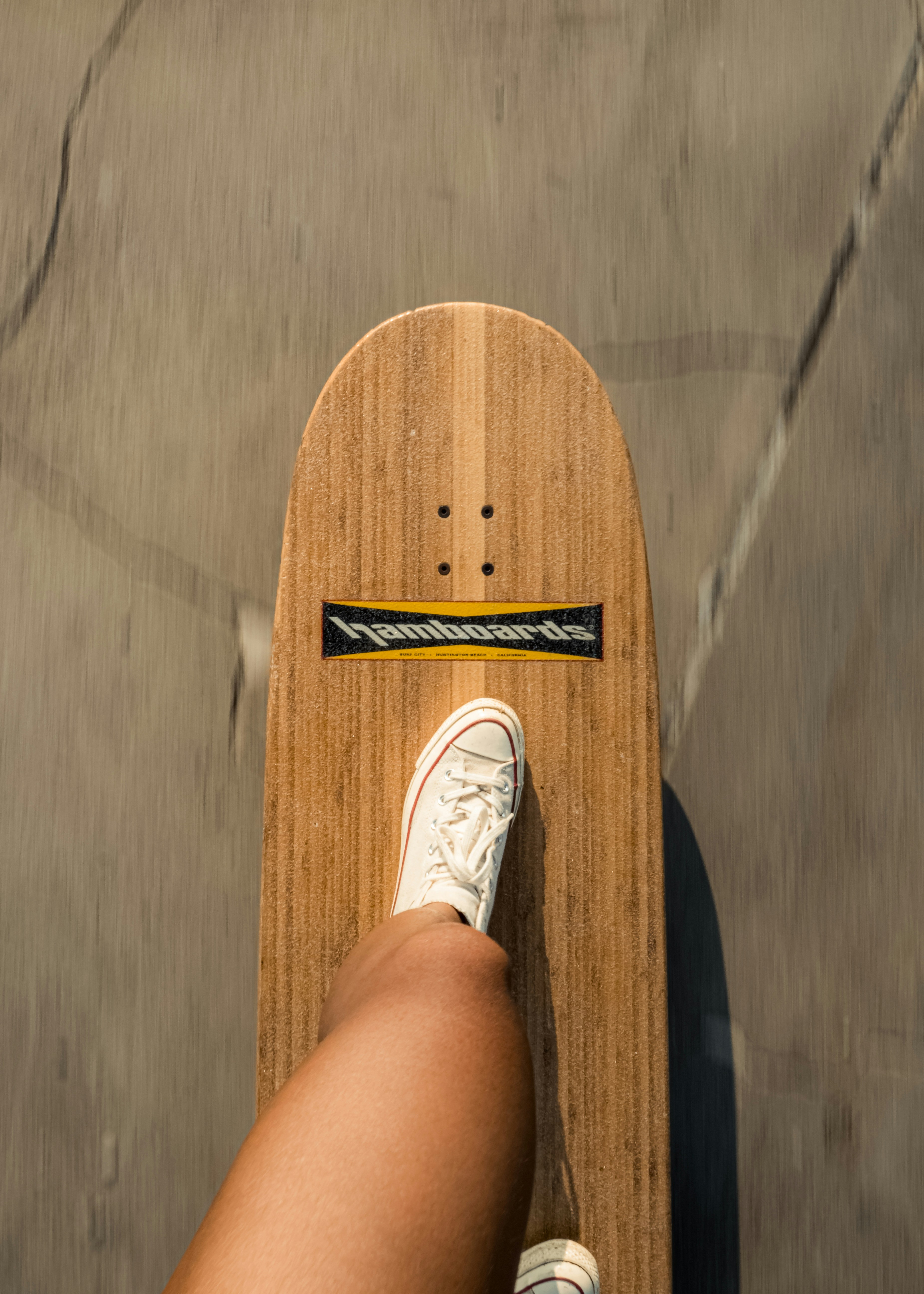Longboard by Skateboard Brands a person standing on a skateboard with their feet on the board